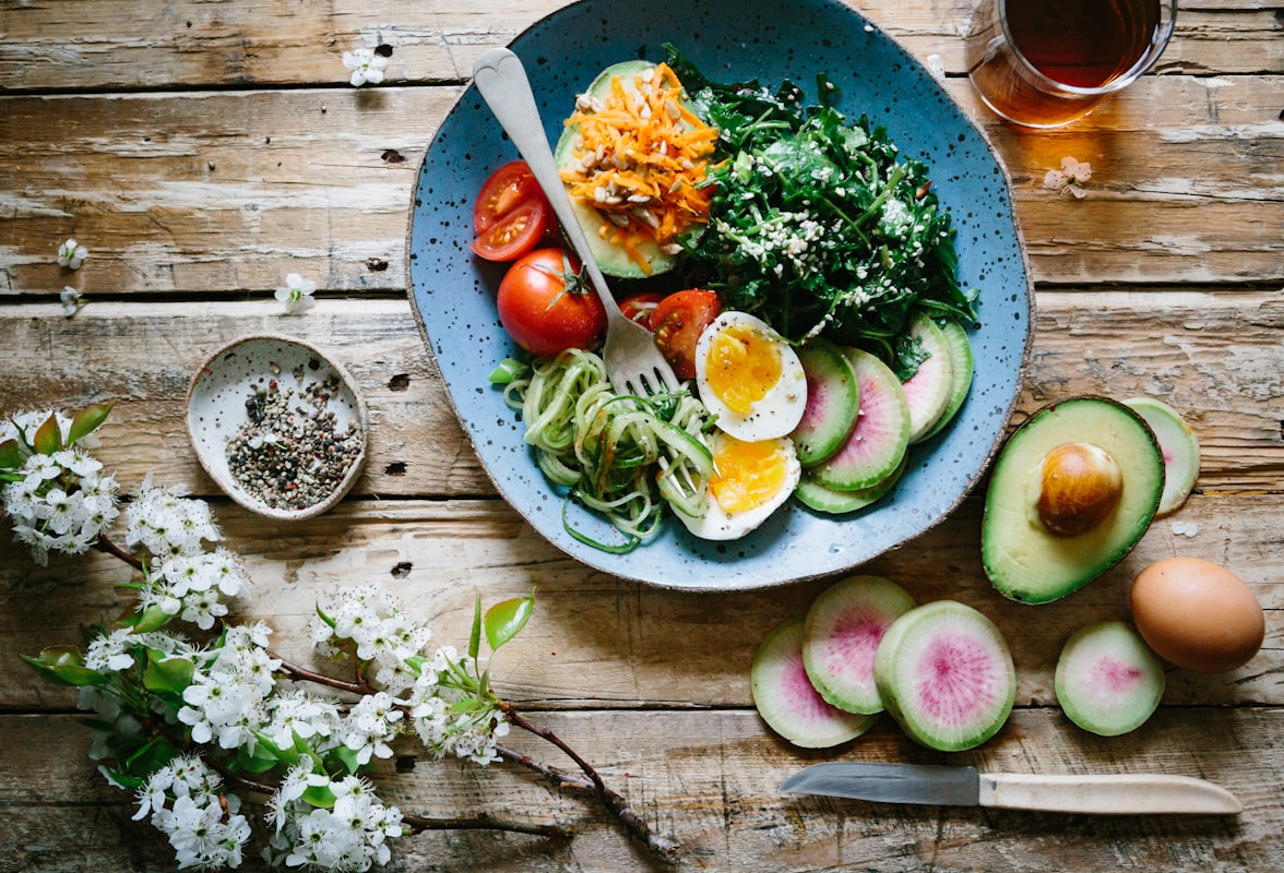 Steaming bowl of plant-based curry with coconut milk and seasonal vegetables